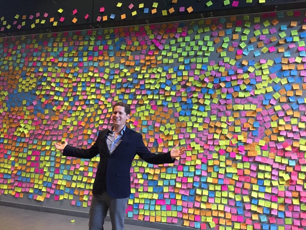 Eduardo Lebrija facing a wall of post-it notes from a strategic session — Founder & CEO of Phil Innovation